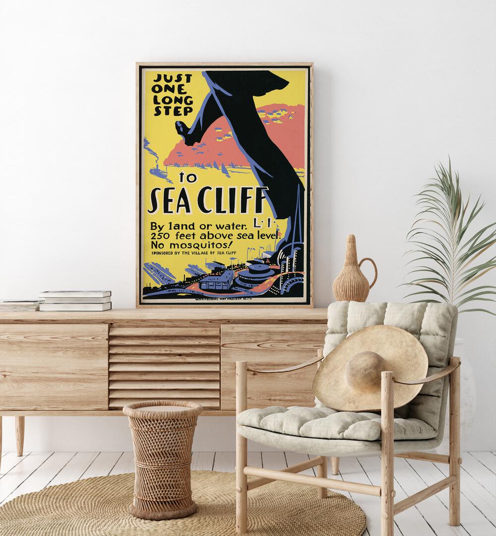 Sea Cliff I Retro Vintage Travel Vintage Travel Posters in Oak Wood Plain Frame on a console table beside a plant