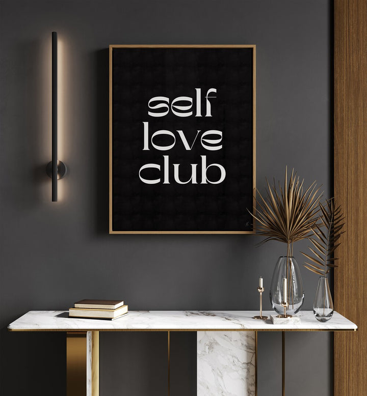 Self Love Club by Anne-marie Volfova Quotes and Typography Posters in Oak Wood Plain Frame placed on a wall behind a table