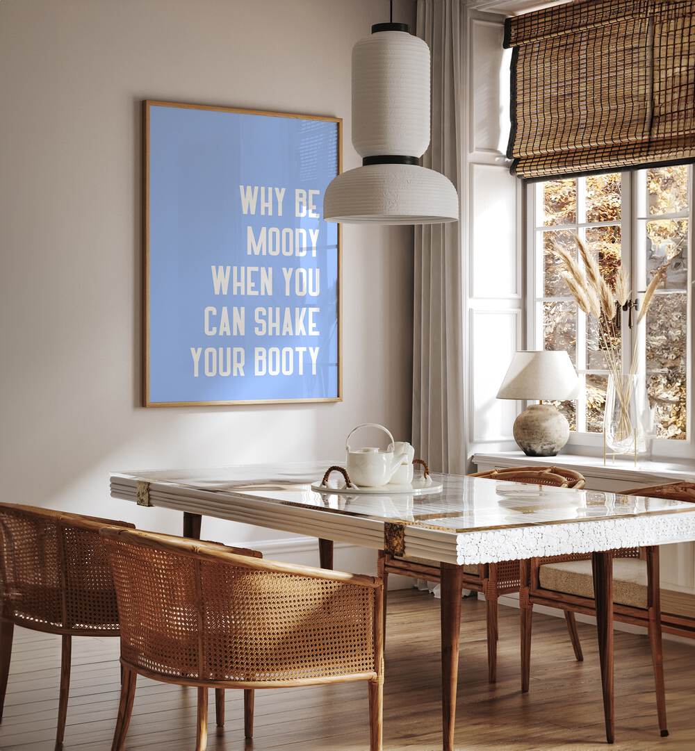 Shake Thy Booty by Athene Fritsch Quotes and Typography Posters in Oak Wood Plain Frame placed on a wall in a dining room area beside a window and behind a dining table 