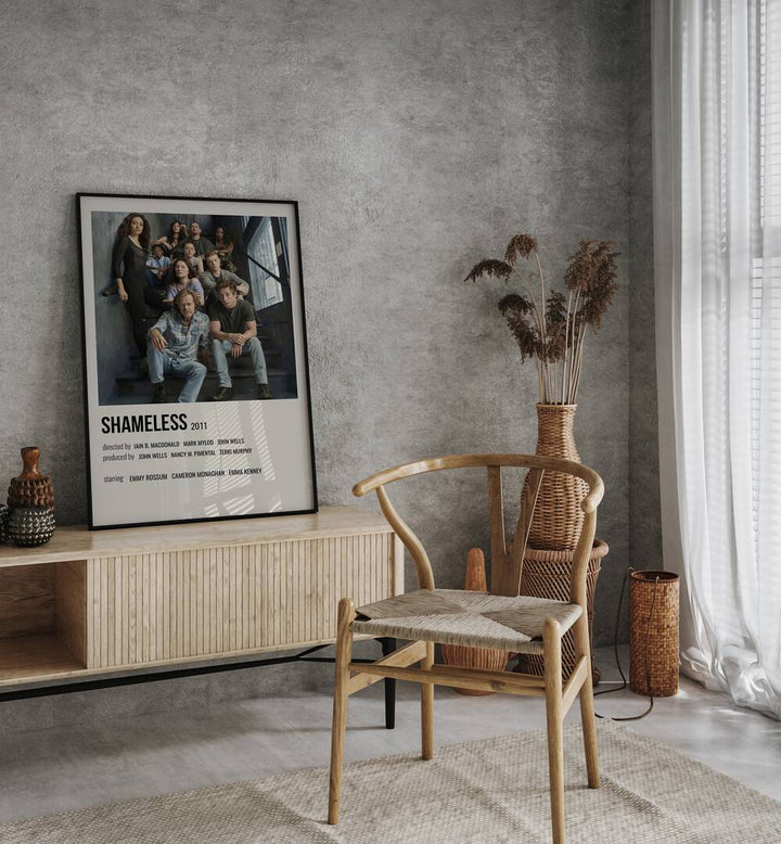 Shameless 2011 I Movie Posters in Black Plain Frame placed on a table beside oakwood chair