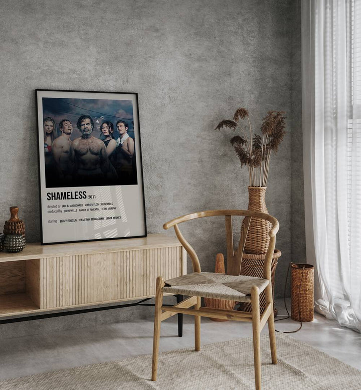 Shameless 2011 ii Movie Posters in Black Plain Frame placed on a table beside oakwood chair