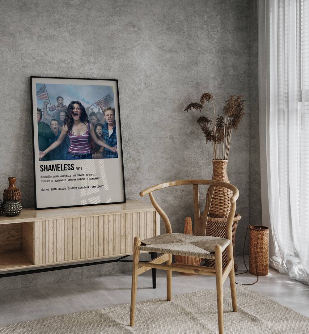 Shameless 2011 iii Movie Posters in Black Plain Frame placed on a table beside oakwood chair