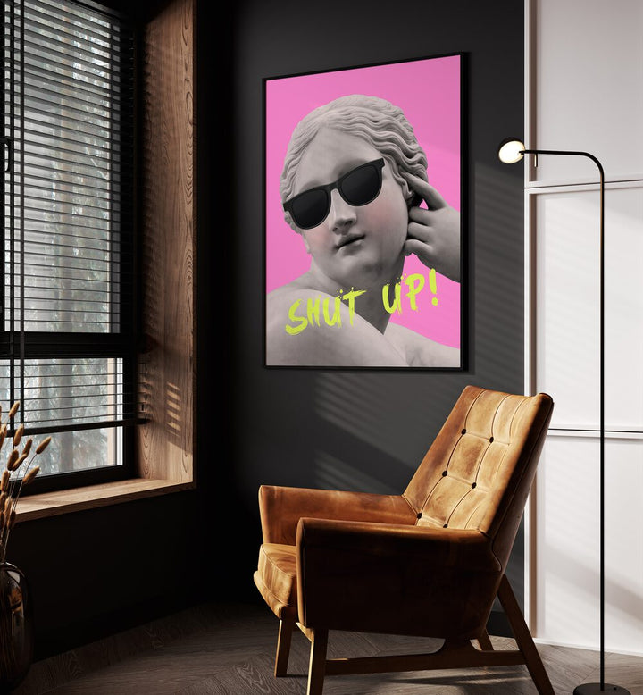 Shut Up Pink Yellow By Grace Digital Art Co Altered Art Prints in Black Plain Frame placed on a wall beside an orange sofa and a window