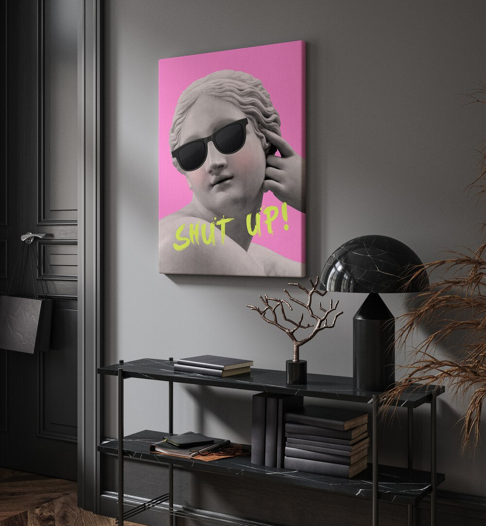 Shut Up Pink Yellow By Grace Digital Art Co Altered Art Prints in Gallery Wrap placed on a wall behind a black table and beside a door