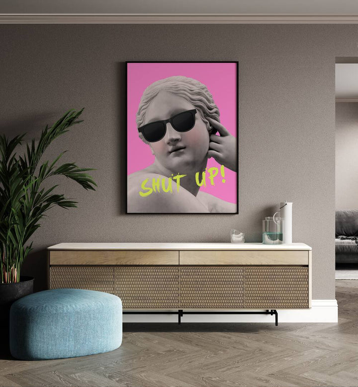 Shut Up Pink Yellow By Grace Digital Art Co Altered Art Prints in Black Plain Frame placed on a wall behind a console table 