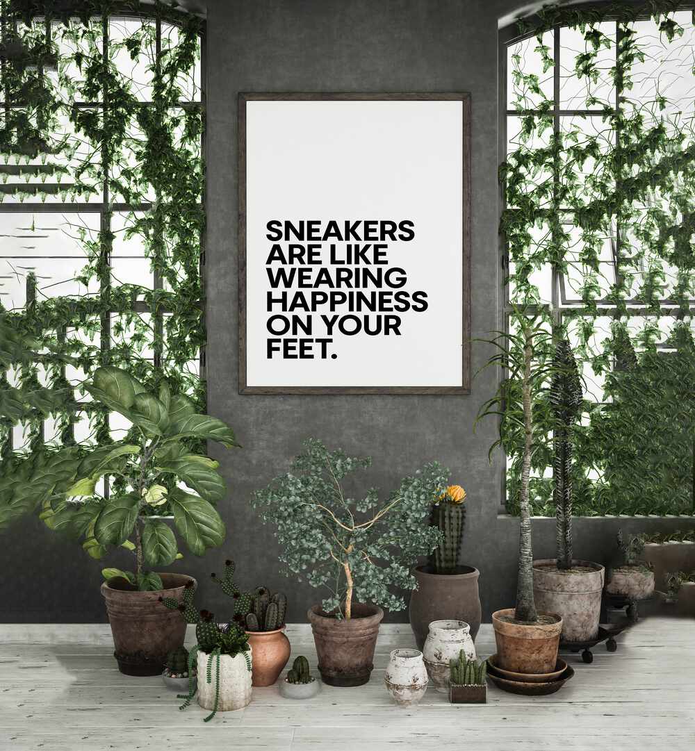 Sneakers Are Happiness Quotes and Typography Posters in Black Plain Frame placed on a wall between windows behind plants