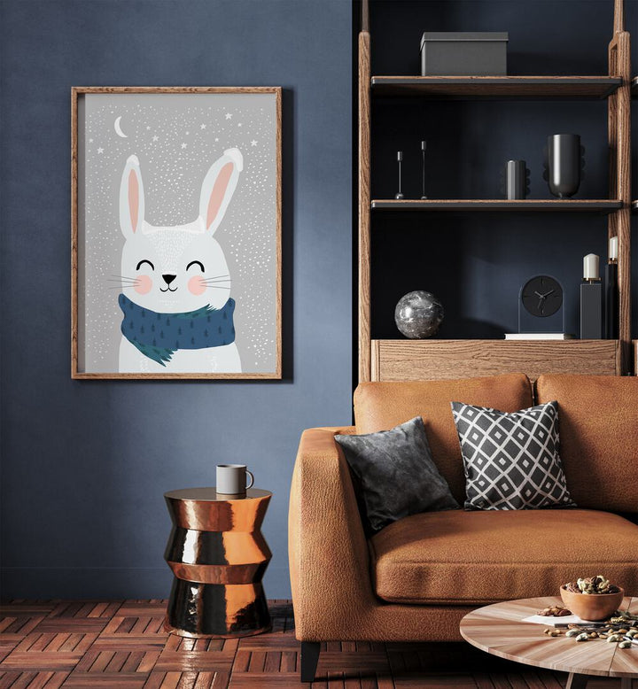 Snow Bunny By Treechild Kids Paintings in Oak Wood Plain Frame placed on a Blue Colored Wall near a Brown Sofa in the Living Room