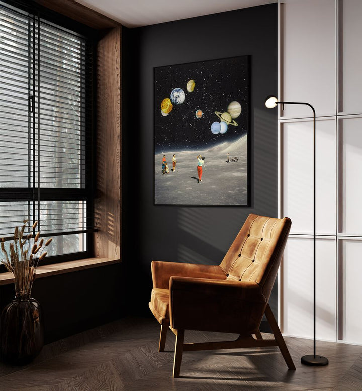 Space Golf Surreal Paintings Surreal Art Prints in Black Plain Frame placed on a Dark Grey Colored Wall near a Brown Sofa Chair in the Drawing Room