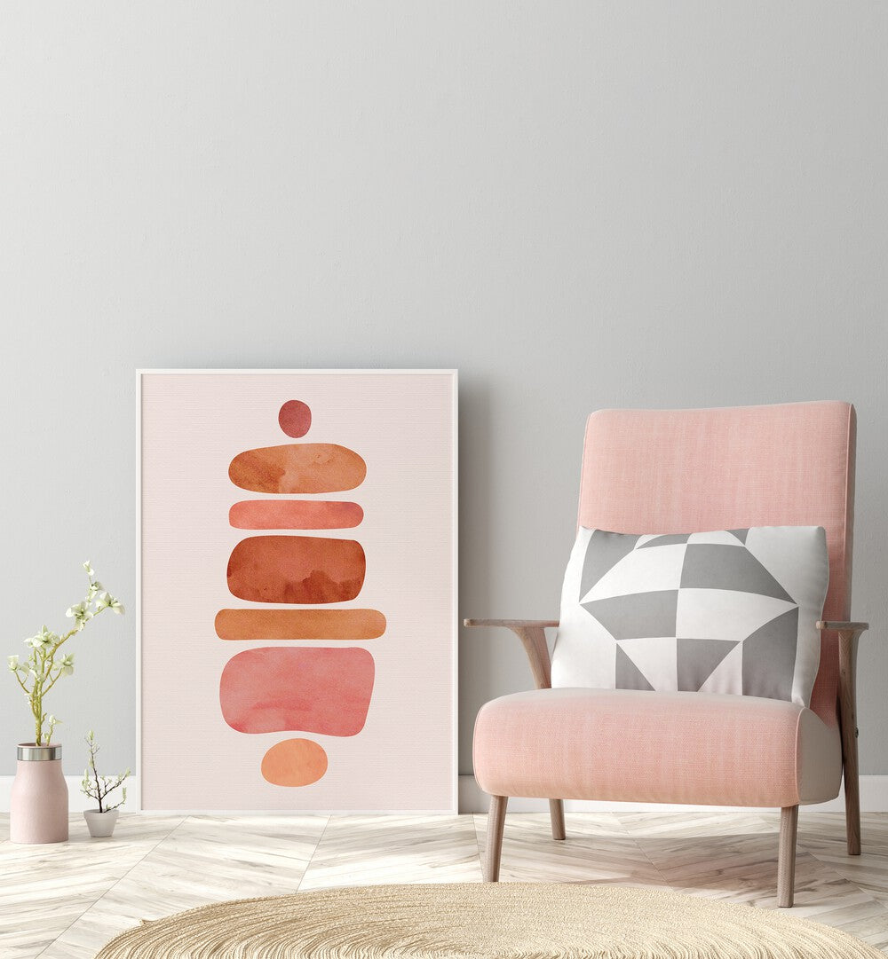 Stacked Stones by Kristian Gallagher Boho Wall Art Paintings Boho Art Prints in White Plain Frame placed on the floor beside a chair