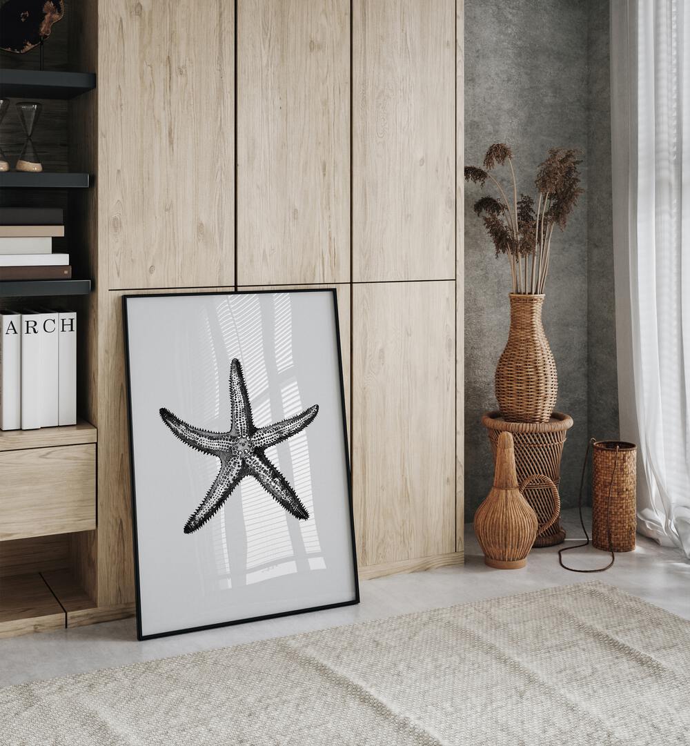 Star Beach Prints Coastal Wall Art in Black Plain Frame placed on the floor near a Wooden Cabinet in the Drawing Room