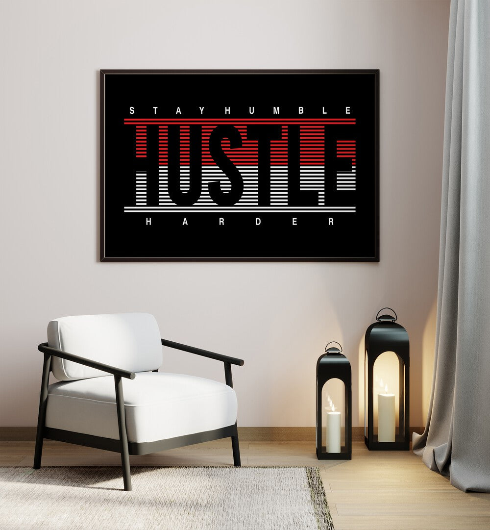 Stay Humble Hustle Harder ii Quotes and Typography Posters in Black Plain Frame placed on a wall beside a chair