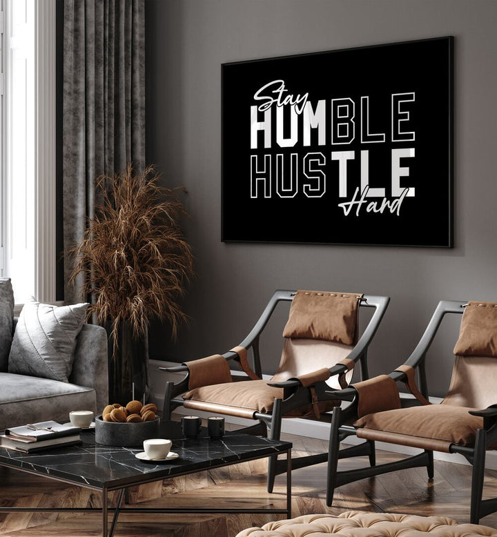 Stay Humble Hustle Harder iii Money Quotes Posters in Black Plain Frame placed on a wall in living room behind chairs