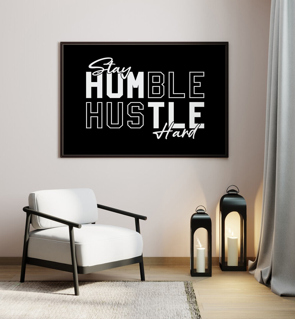 Stay Humble Hustle Harder iii Quotes and Typography Posters in Black Plain Frame placed on a wall beside a chair