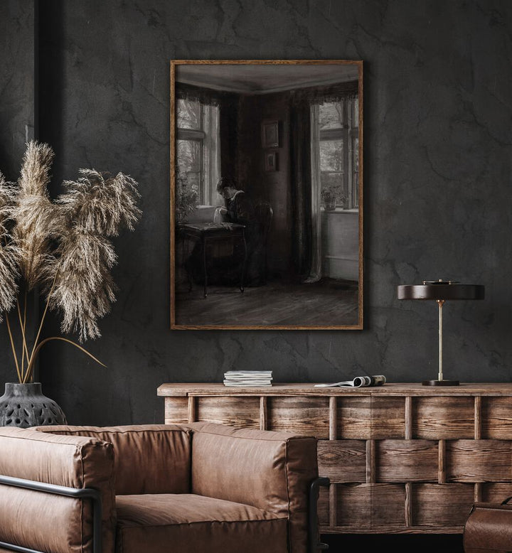 Stitching Shadows Gothic Threads Of Fate Gothic Art Prints in Oak Wood Plain Frame hanging on wall above brown chair beside plant.