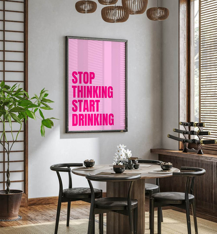 Stop Thinking Start Drinking by Athene Fritsch Quotes and Typography Posters in Black Plain Frame placed on a wall in a dining room area beside a window and behind a dining table