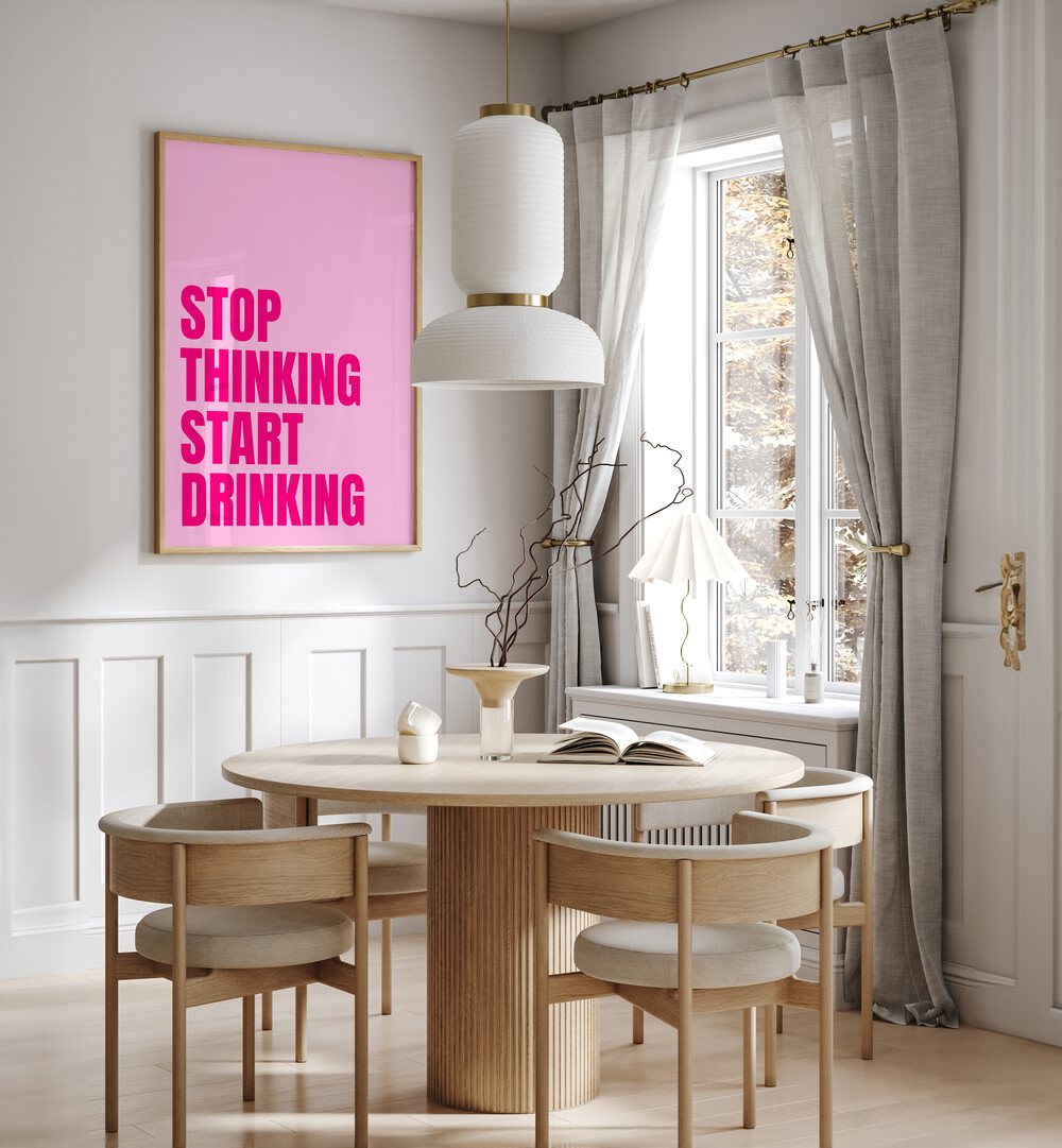 Stop Thinking Start Drinking by Athene Fritsch Quotes and Typography Posters in Oak Wood Plain Frame placed on a wall in a dining room area beside a window and behind a dining table