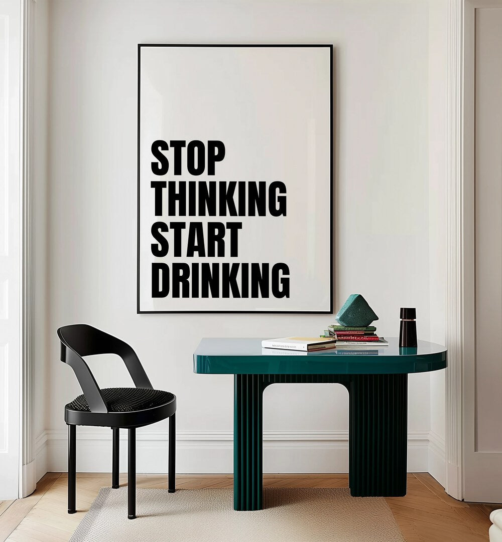 Stop Thinking Start Drinking ii by Athene Fritsch Quotes and Typography Posters in Black Plain Frame placed on a wall behind a study table