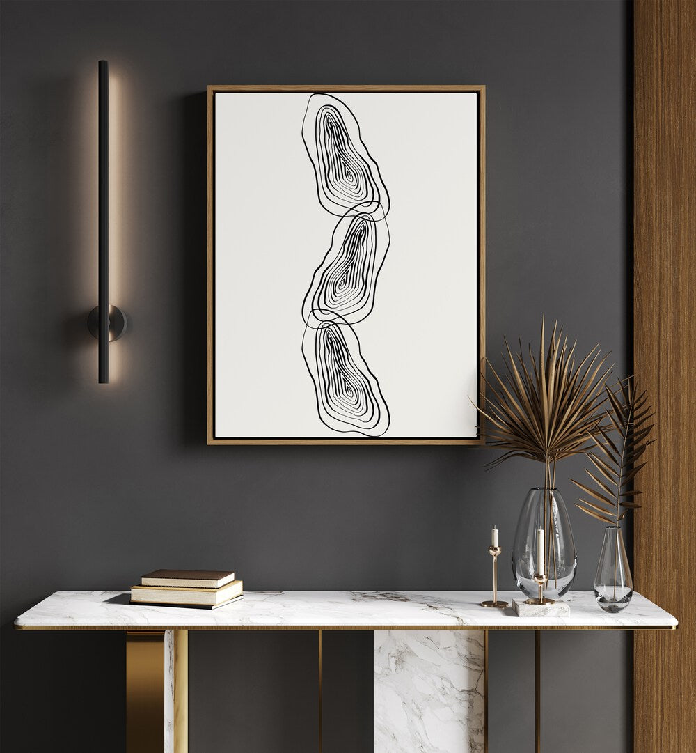 String Of Wood By Grishma Korjani Line Art Prints in Oak Wood Floater Frame placed on a Dark Grey Colored Wall above a Console Table