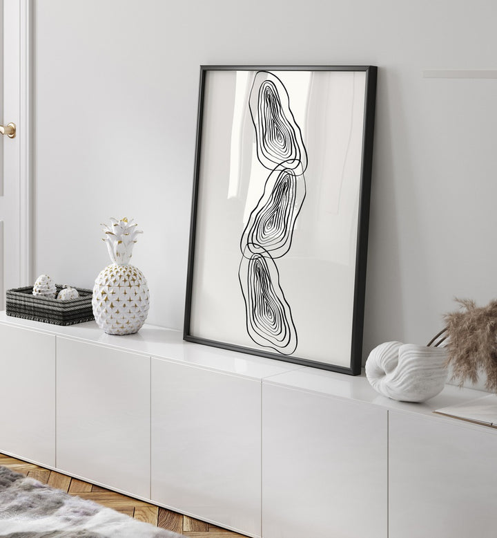 String Of Wood By Grishma Korjani Line Art Prints in Black Plain Frame placed on a Console Table near a White Colored Wall