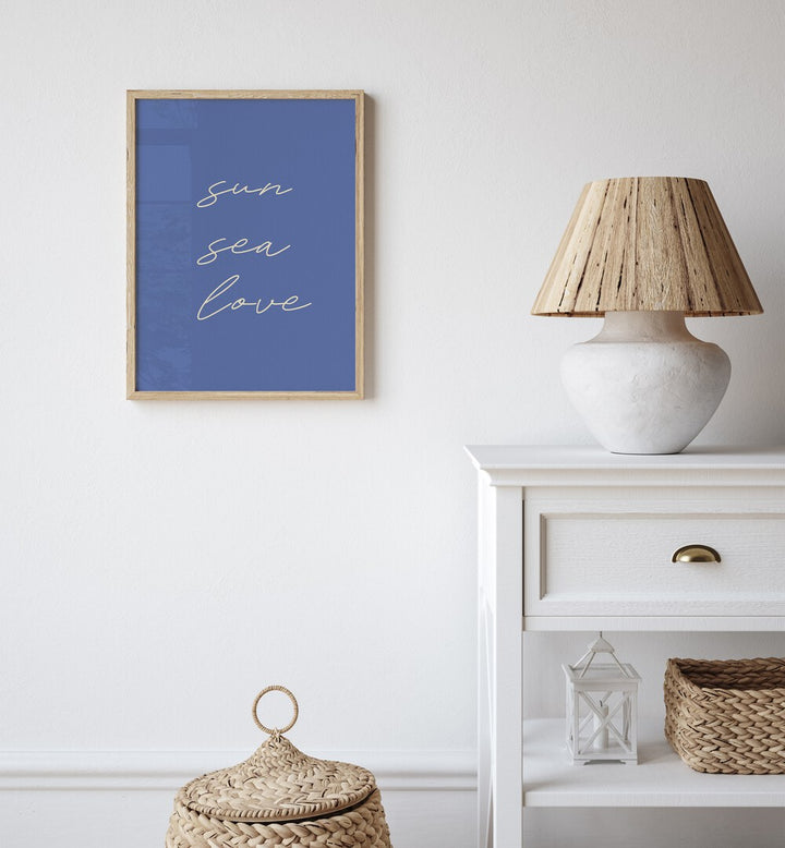 Sun Sea Love Beach Prints Coastal Wall Art in Oak Wood Plain Frame placed on a White Colored Wall in the Living Room