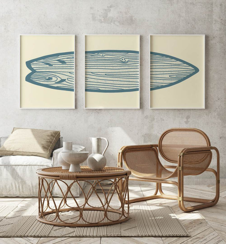 Surf Board Artworks Set Of 3 Paintings in White Plain Frame placed beside a sofa and behind a chair