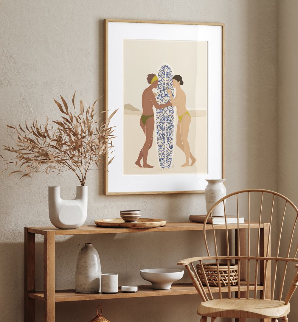 Surfing Connects People By Andi Bell Beach Prints in Oak Wood Frame With Mount on a cream wall placed above a table