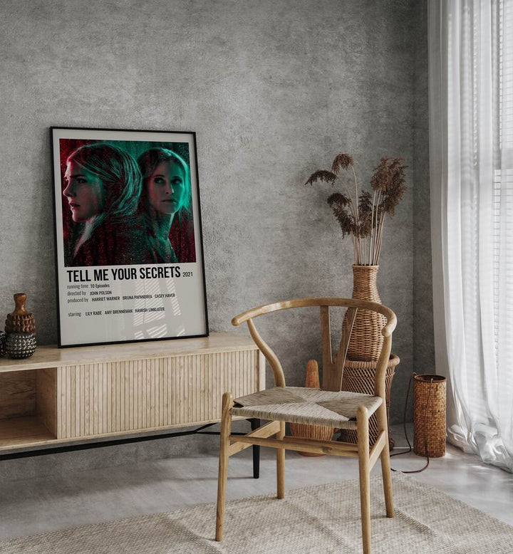 Tell Me Your Secrets 2021 Movie Posters in Black Plain Frame placed on a console behind a chair