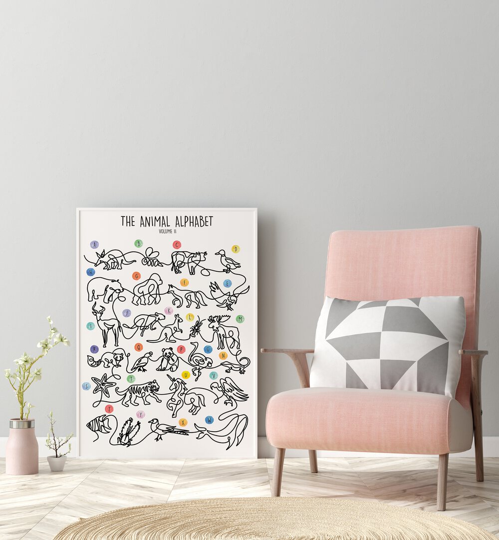 The Animal Alphabet Volume II by Hanna Lee Tidd Kids Room Paintings in White Plain Frame placed on the floor beside a chair