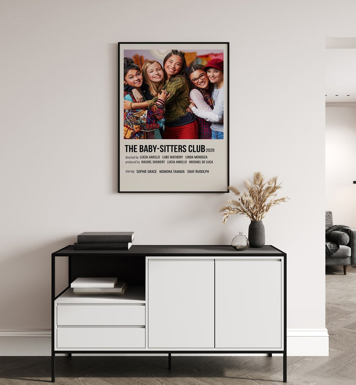 The Baby-sitters Club 2020 Movie Posters in Black Plain Frame placed on a white wall behind a black and white table