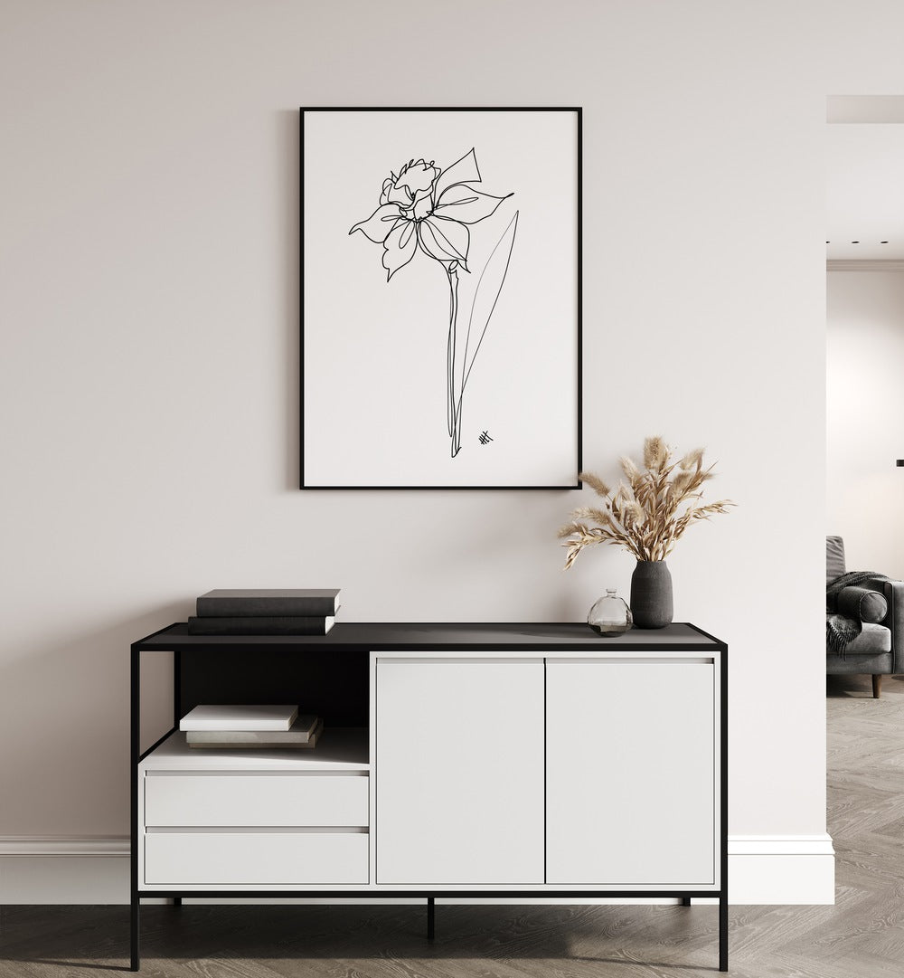 The Daffodil by Hanna Lee Tidd Line Art Paintings Line Art Prints in Black Plain Frame placed on a wall behind a table