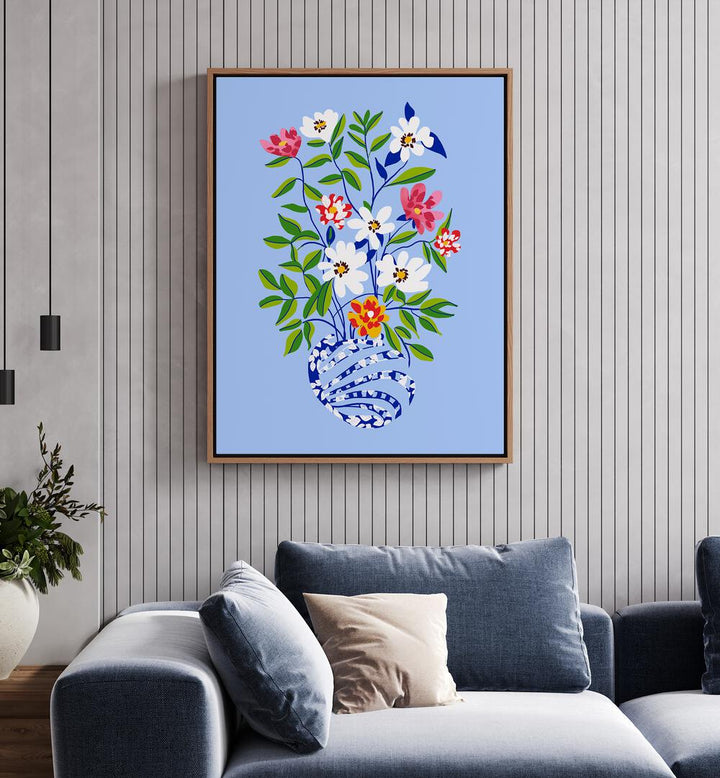 The Floopy Planter By Uma Gokhale Botanical Paintings in Oak Wood Floater Frame on a white wall behind a sofa