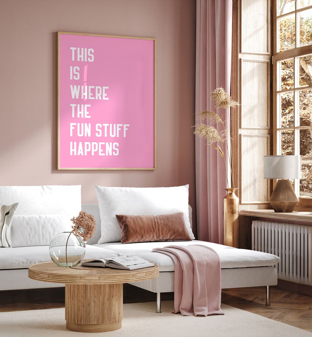 The Fun Stuff by Athene Fritsch Quotes and Typography Posters in Oak Wood Plain Frame placed on a pink wall beside a window and behind a sofa for living room