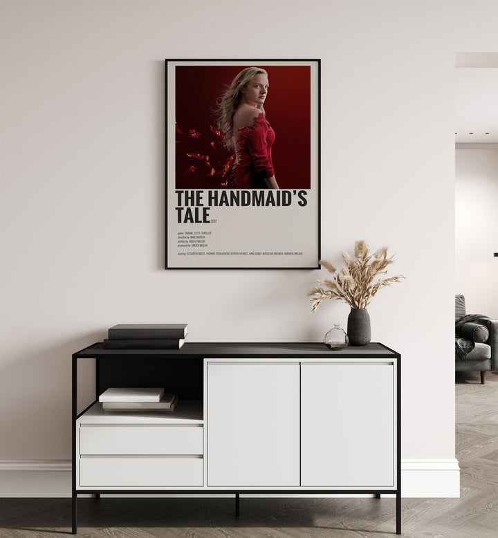 The Handmaids Tale 2017 Movie Posters in Black Plain Frame placed on a white wall behind a table