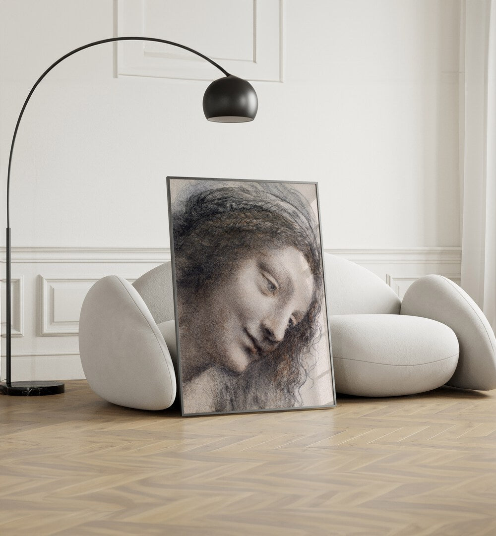 The Head Of The Virgin C.1510–1513 Vintage Paintings in Black Plain Frame placed on the floor beside a sofa and a lamp