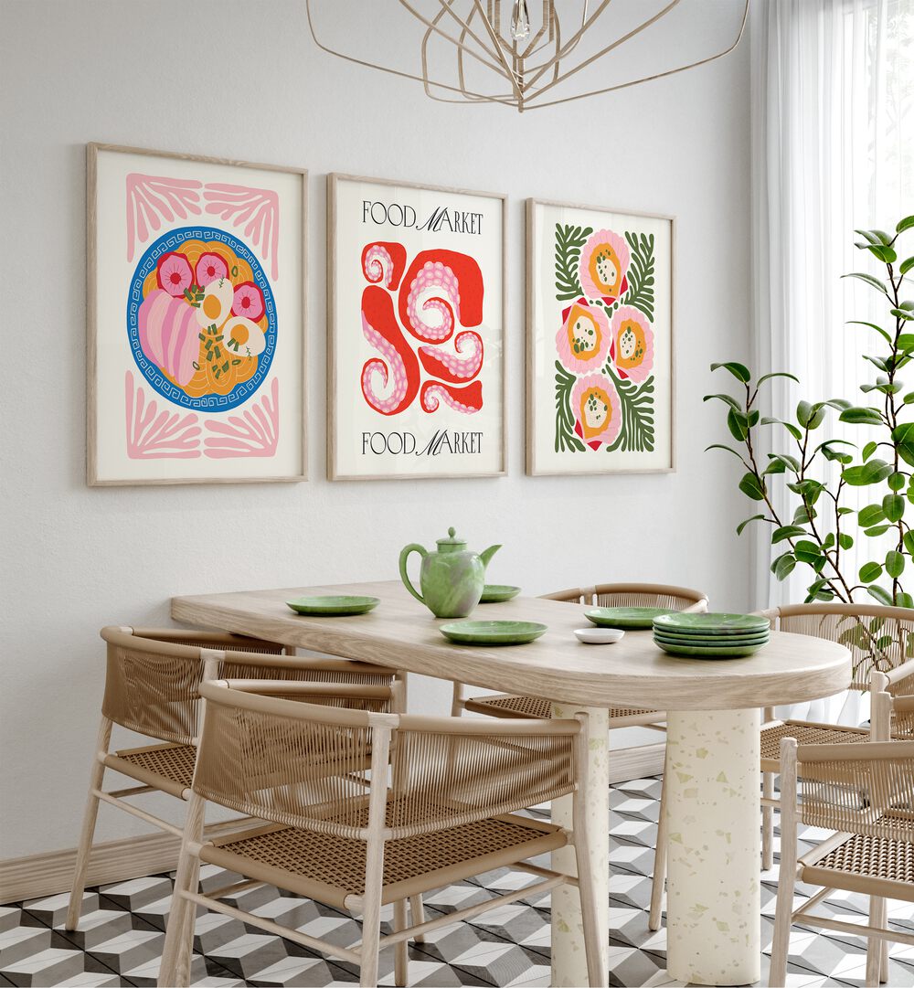 The Kitchen Set Set Of 3 Paintings in Oak Wood Plain Frame placed on a white wall behind a dining table and beside a window for dining area