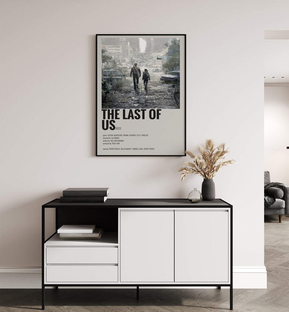 The Last Of Us 2023 Movie Posters in Black Plain Frame placed on a white wall behind a table