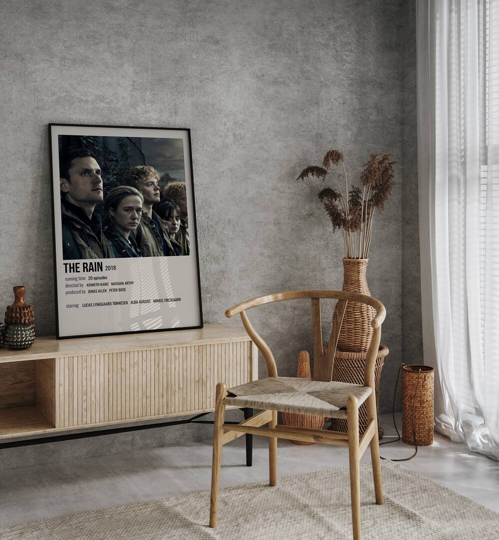 The Rain 2018 Movie Posters in Black Plain Frame placed on a console behind a chair