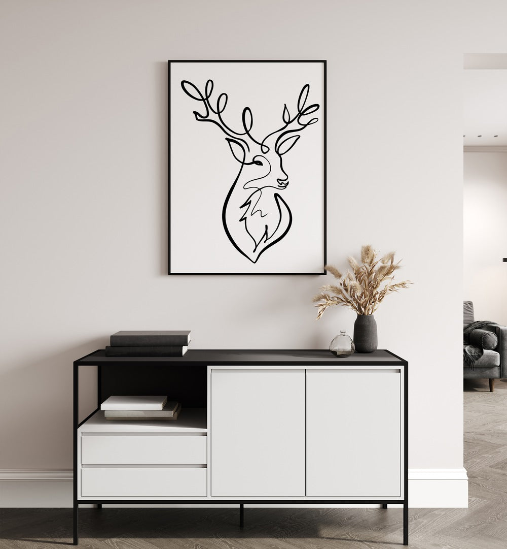 The Stag by Hanna Lee Tidd Line Art Paintings Line Art Prints in Black Plain Frame placed on a wall behind a table