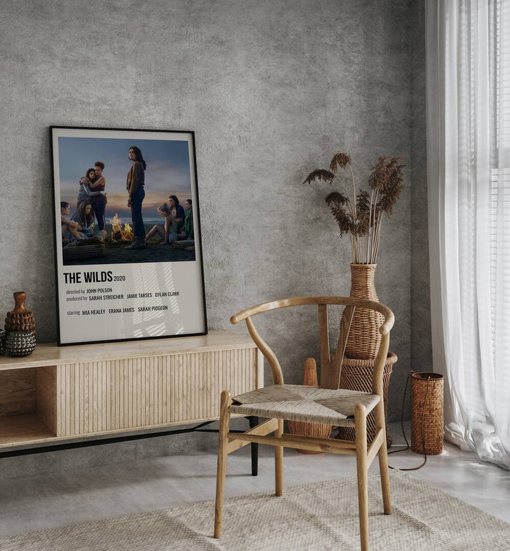 The Wilds 2020 Movie Posters in Black Plain Frame placed on a console behind a chair