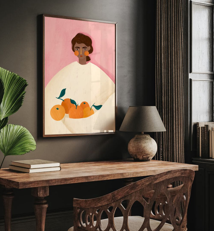 The Woman With the Oranges By Bea Muller Women Illustration Paintings in Dark Wood Plain Frame on a grey wall above a study table beside a plant