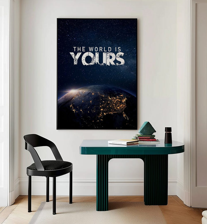 The World Is Yours Quotes And Typography Posters in Black Plain Frame placed on a Cream Colored Wall near a Study Table in a Workspace in the Drawing Room