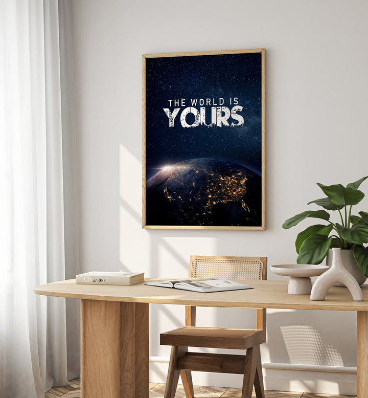 The World Is Yours Quotes And Typography Posters in Oak Wood Plain Frame placed on a White  Colored Wall near a Study Table in a Workspace in the Drawing Room