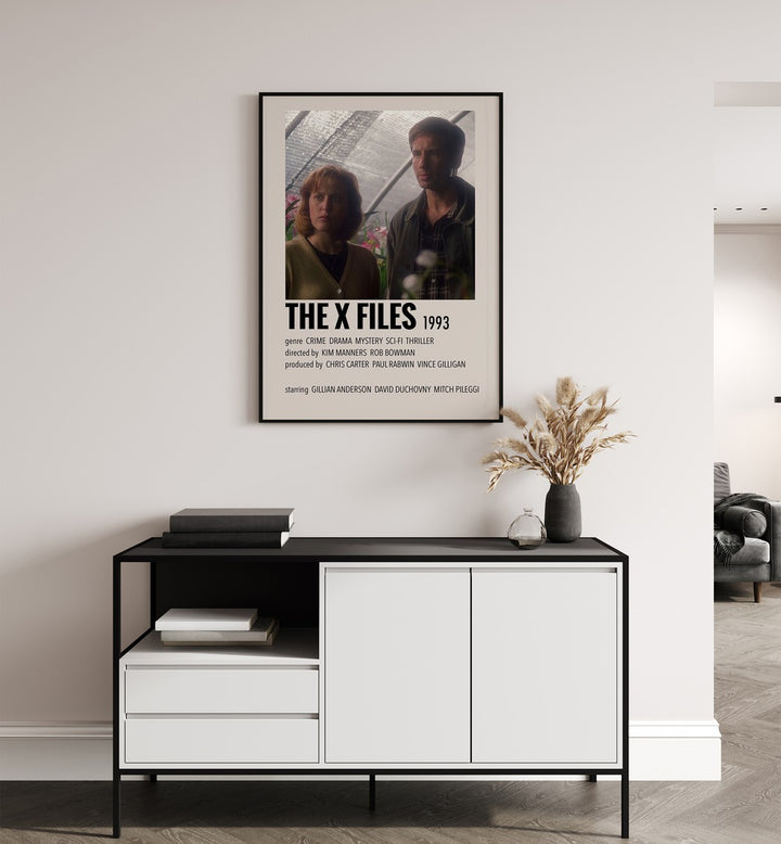 The X Files 1993 Movie Posters in Black Plain Frame placed on a white wall behind a table