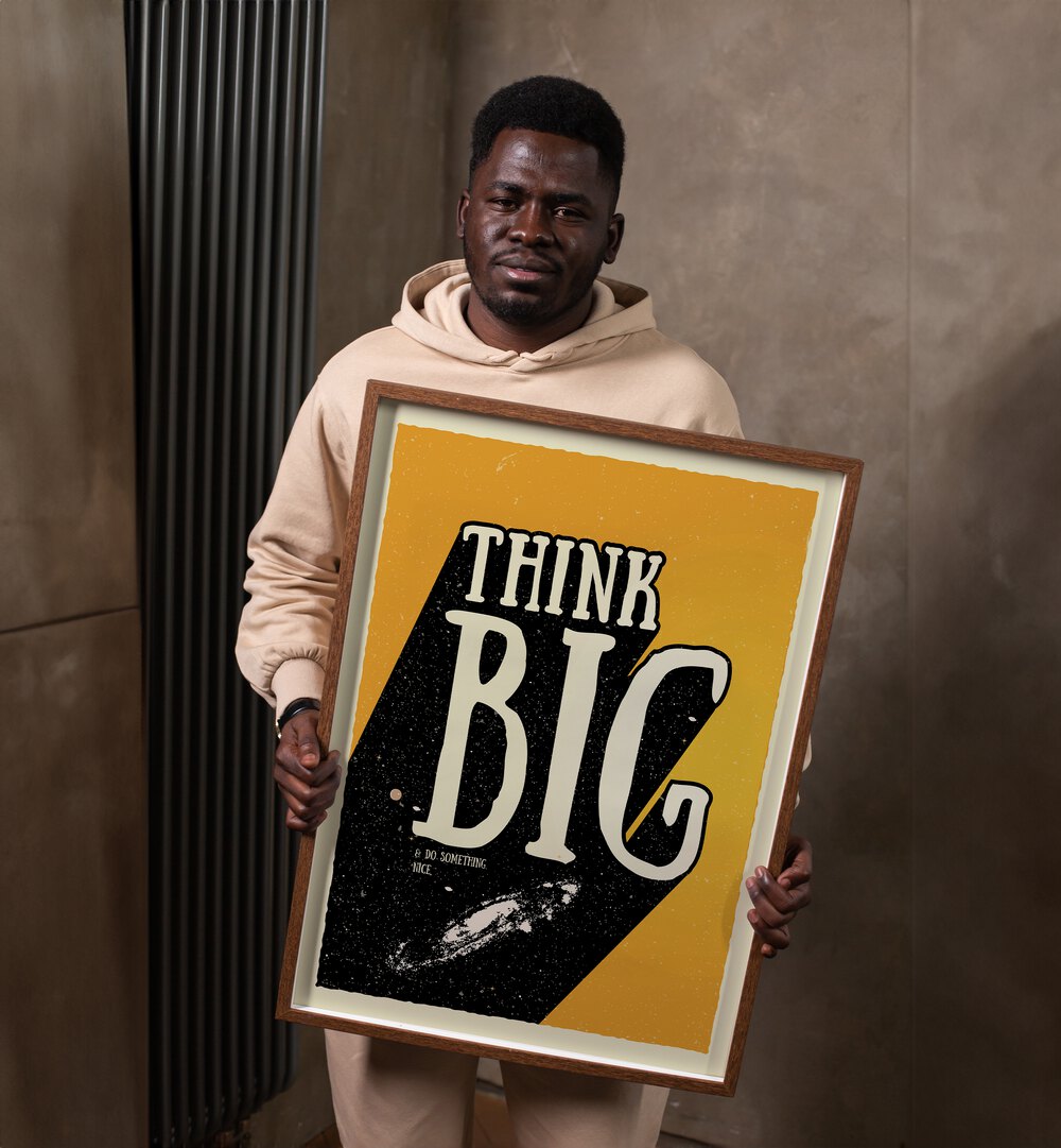 Think Big Quotes and Typography Posters in Dark Wood Plain Frame a human model holding the artwork