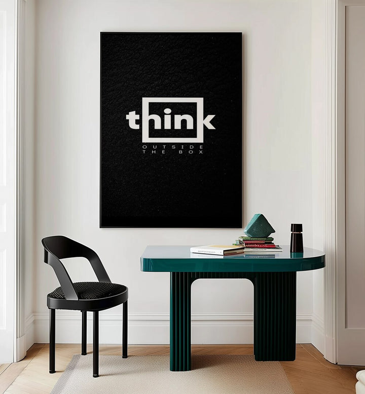 Think Outside The Box Quotes And Typography Posters in Black Plain Frame placed on a Cream Colored Wall near a Study Table in a Workspace in the Drawing Room