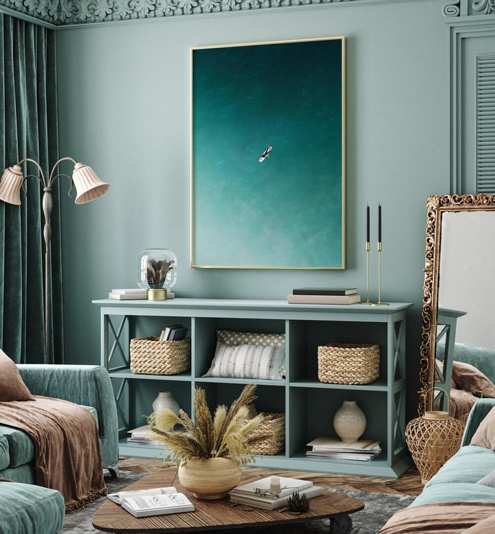 Tranquility Beach Prints Coastal Wall Art in Gold Plain Frame placed on a Turquoise Colored Wall above a Shelf in the Living Room