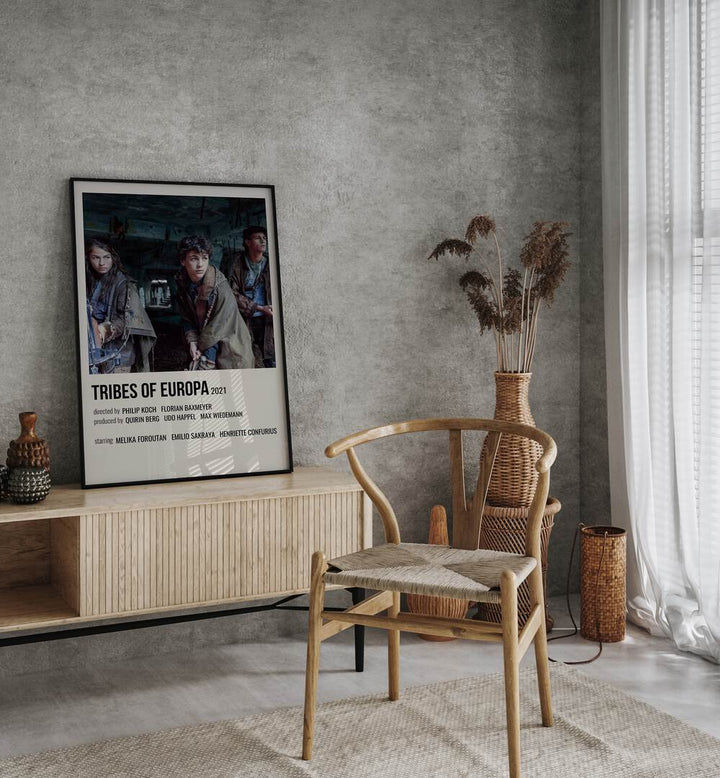 Tribes Of Europa 2021 Movie Posters in Black Plain Frame placed on a console behind a chair