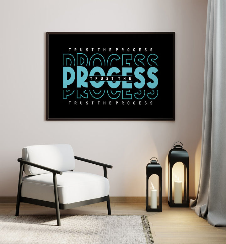 Trust the Process Quotes and Typography Posters in Black Plain Frame placed on a wall in a room beside a chair