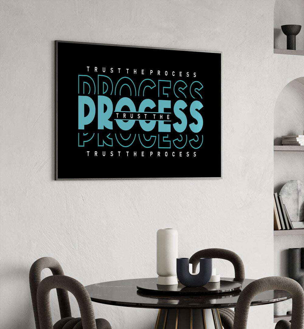 Trust the Process Quotes and Typography Posters in Black Plain Frame placed on a wall behind a dining table