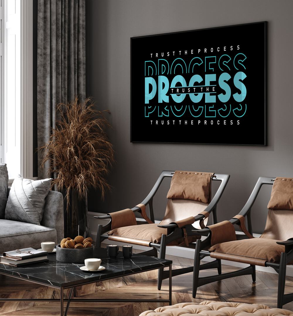 Trust the Process Quotes and Typography Posters in Black Plain Frame placed on a wall in living room behind chairs